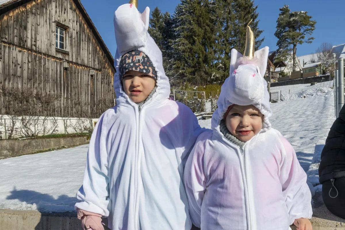 Die Einhörner sind aus Winterthur angeritten gekommen, wenn schon ein Kostüm dann soll es auch gebraucht werden, sagt Mutter Einhorn. Zwei Kinder in Einhornkostümen blicken in die Kamera.